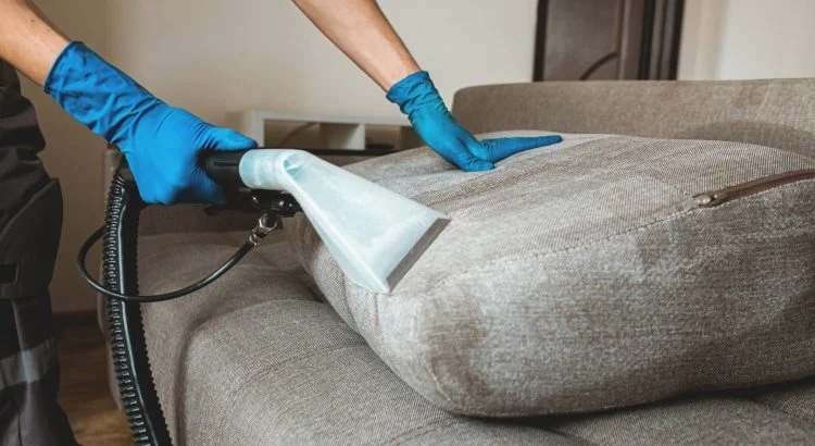 Technicien nettoyant un canapé à la shampouineuse